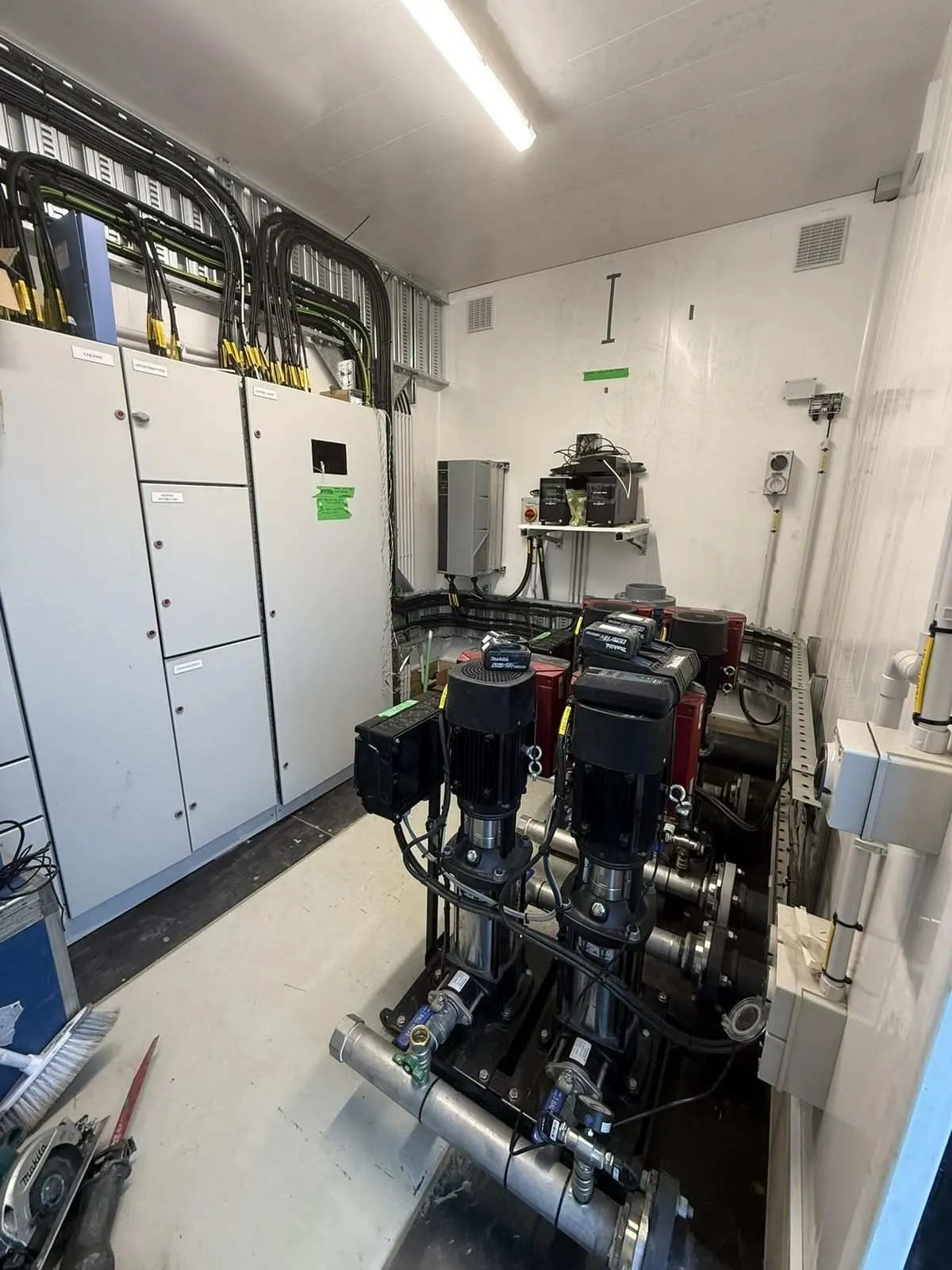 Pump room interior showing booster pump set and electrical switchboards