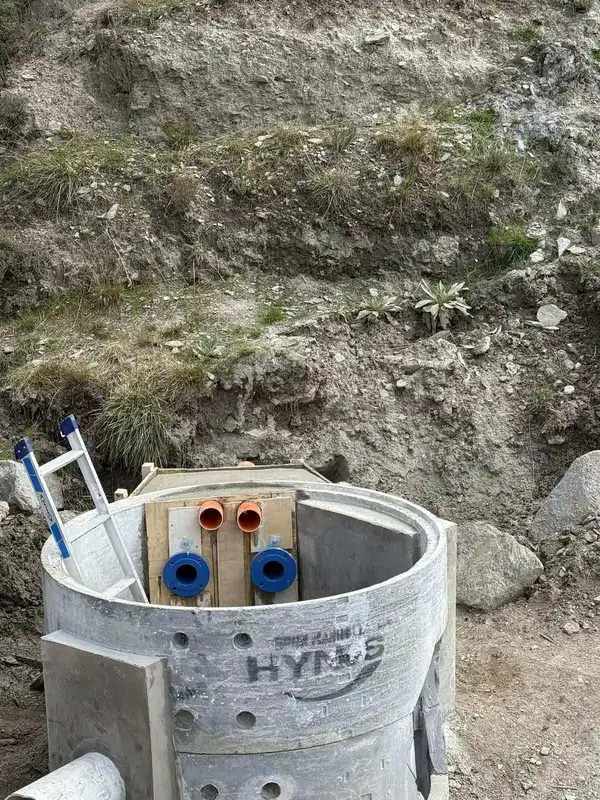 Concrete precast valve chamber with blue and orange pipe connections